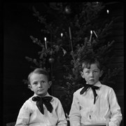 Cover image of Elliott Jr. and Robert Barnes looking at photographs under Christmas tree