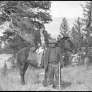 Cover image of Unidentified woman on horse with man standing by horse