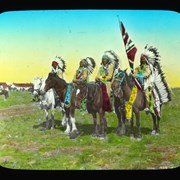Cover image of [Four First Nations men on horseback, with one man holding Union Jack flag. Unidentified white log buildings in background]