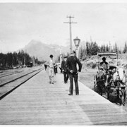 Cover image of [Men standing on platform next to railway tracks - enhanced]