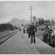 Cover image of [Men standing on platform next to railway tracks]