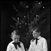 Cover image of Elliott Jr. and Robert Barnes looking at photographs under Christmas tree