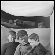 Cover image of Robert, Elliott and Elliott Jr. Barnes looking at book