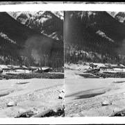 Cover image of Men and teams stacking logs in front of camp buildings