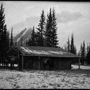 Cover image of Elliott Barnes' cabin with Elliott Peak in the background,  [Kootenay Plains]