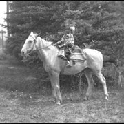 Cover image of Unknown child in regalia on horse, part of the Rider familly