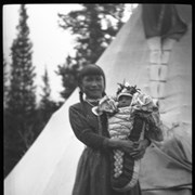 Cover image of Unknown woman holding baby outside tipi