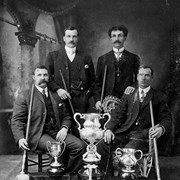 Cover image of Ed Ekhurst, W. Green (standing), J. Thomson, J. McRavey (seated) with curling trophies