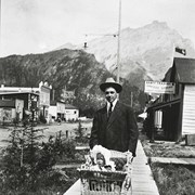 Cover image of Clarence Lougheed pushing Cyril Paris on Banff Avenue