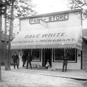 Cover image of Dave White's [Park] Store - left to right: Mr. Lumley, unidentifed, Archie Howard, Annie White with baby Clifford, Dave White