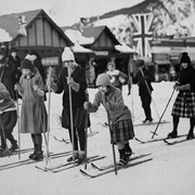 Cover image of Start of girls ski rance on Banff Avenue during Banff Winter Carnival, Jim Brewster (second from right) officiating