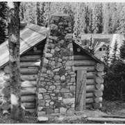 Cover image of Log building with stone chimney