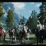 Cover image of Eliza Hunter (Wîchîyânâgish) (Young Woman) (center), Peggy (Rider) Bearspaw and other unknown individuals preparing for Banff Indian Days parade