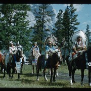 Cover image of Peggy (Rider) Bearspaw (left), unknown, unknown and Leah (Rider) Hunter (right), getting ready for Banff Indian Days parade